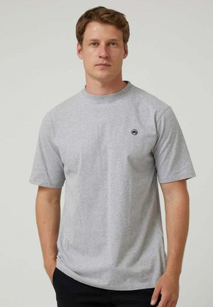Camiseta de algodón gris de manga corta con cuello redondo y un pequeño logo negro en el pecho. Corte regular y textura suave.