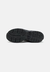 Sola de sapato atlético preto com uma aderência texturizada e padronizada, apresentando linhas de sulcos profundas e ranhuras para tração em várias superfícies.
