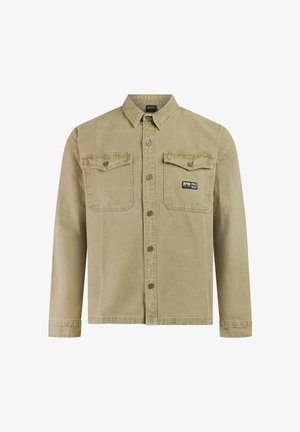 Beige overhemd met lange mouwen en knopen, voorzien van twee borstzakken waarvan één met een "PROTEST" logo patch, en een puntige kraag.