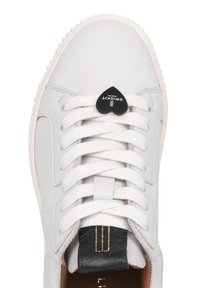 Sneaker in pelle bianca con lacci bianchi piatti, un'etichetta a forma di cuore nera e un accento sul tallone in pelle nera texturizzata. Superficie liscia e punta arrotondata.