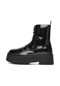 Czarne botki za kostkę sznurowane, wykonane z błyszczącej skórki lakierowanej, z grubą, wytrzymałą podeszwą platformową oraz pętelką na pięcie ułatwiającą zakładanie.