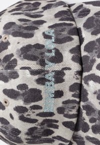 Gorra de estampado de leopardo en corduroy gris y negro con bordado turquesa que dice "BAYLOR". Presenta detalles de costura y una textura sutil.