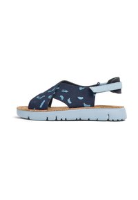 Siniset kuvioidut sandaalit korkkipohjalla, joissa on ristiligatuet ja vaaleansiniset kumipohjat. Säädettävä kantaremmi takaa tukevan istuvuuden.