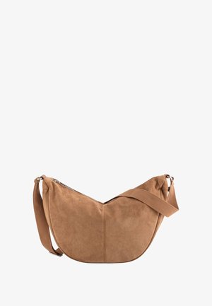 Tan suede shoulder bag with a curved shape, adjustable fabric strap, and a zippered top closure. Smooth texture with subtle stitching details.