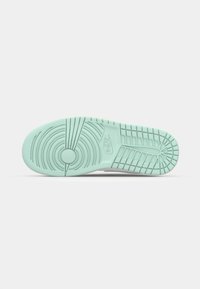 Nike tenisa zole pasteļzaļā krāsā ar teksturētu zoles rakstu, kas ietver koncentriskus lokus un logotipu. Gluda gumijas materiāls.