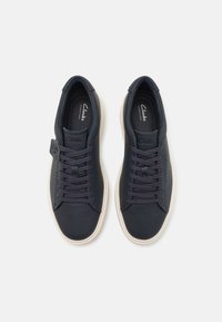 Marineblå lædersneakers med rund tå, flad hvid sål og snørebåndsdesign. Har logo på siden og perforerede detaljer på overdelen.