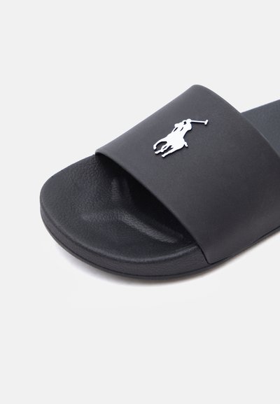 Μαύρο σανδάλι με λουρί, με υφή στην επιφάνεια του πέλματος και φαρδύ λουρί με λευκό λογότυπο παίκτη πόλο.