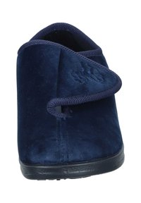 Navy blue slipper with soft, velvety texture, rounded shape, and a simple crossover strap design. Black rubber sole and stitching details.