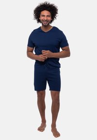 Navyblauw katoenen T-shirt met korte mouwen en een V-hals, gecombineerd met bijpassende shorts met trekkoord, met een relaxte pasvorm en een zachte textuur.