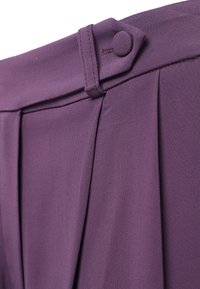 Pantaloni su misura viola con una texture di tessuto liscia, caratterizzati da una chiusura con bottone e pieghe affilate lungo la vita per un design strutturato.