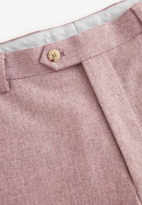 Heller rosa Tweed-Stoff mit einer subtilen Textur, mit einem Knopf und einem plissierten Design am Bund. Die Innenauskleidung ist hellgrau.