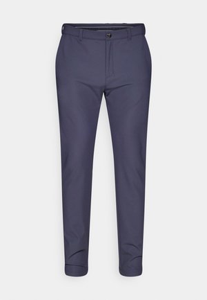 Pantalon bleu marine en tissu lisse, doté d'une fermeture à bouton et éclair, avec une coupe fuselée et des poignets retroussés.
