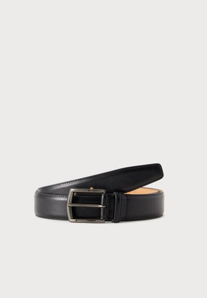 Ceinture en cuir noir avec boucle rectangulaire argentée enroulée sur un fond clair uni.