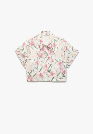 Przykrótka koszula z lekkiego materiału, zdobiona kwiatowym wzorem w różowe i żółte kwiaty na białym tle. Zapięcie na guziki z przodu.