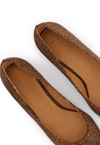 Ballerines marron avec un motif léopard, fabriquées en matériau doux. Bout arrondi et intérieur en cuir lisse avec une marque en relief.