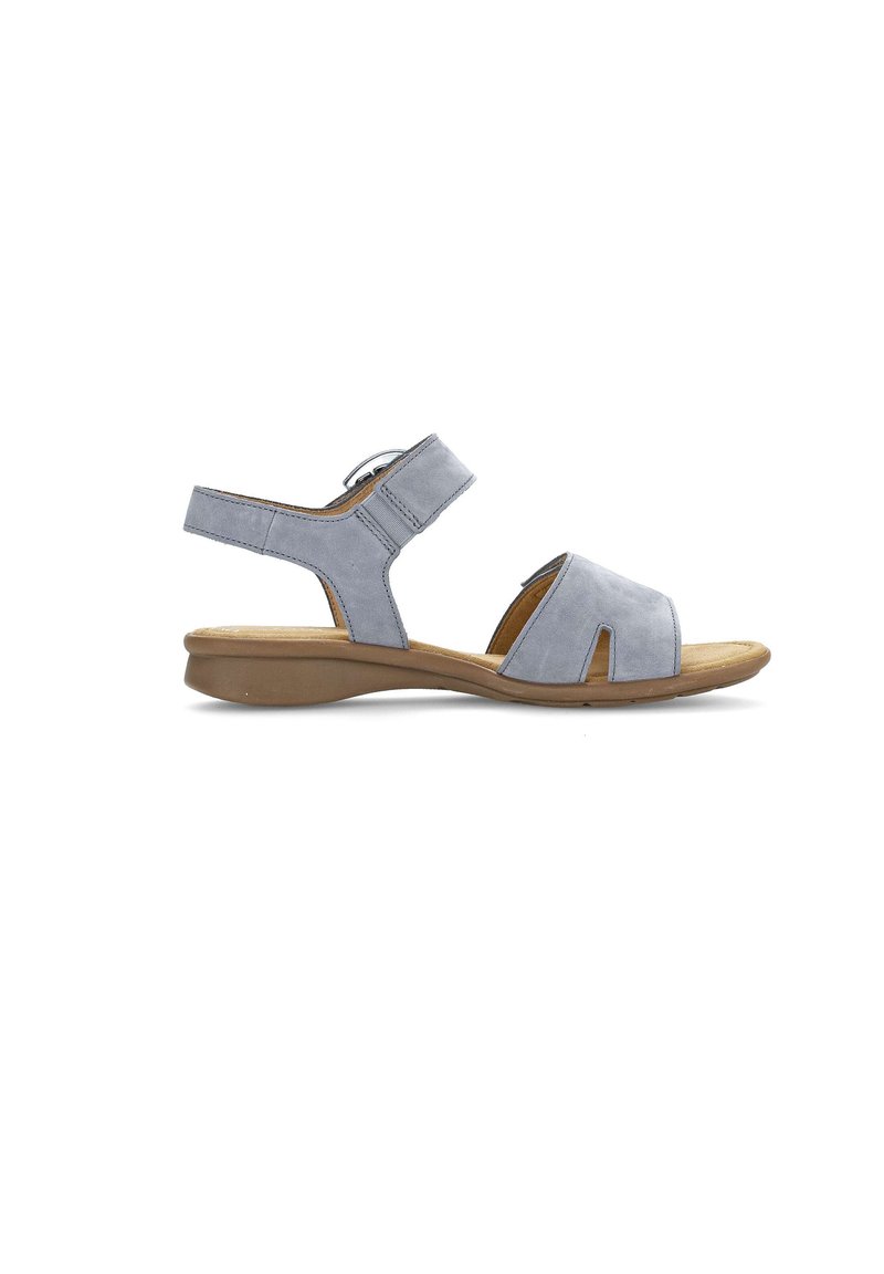 Lichtgrijze suède sandaal met een verstelbare enkelriem, open teen en een gevormde tan kleurige zool. Opvallende uitsparingen aan de voorkant voor ademend vermogen.
