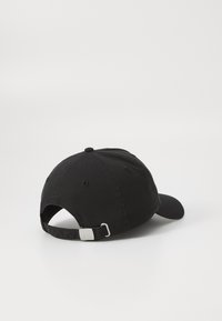 Casquette en coton noir avec visière incurvée, sangle ajustable à l'arrière avec quincaillerie en argent, et finition lisse.