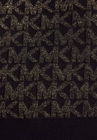 Tessuto nero con un motivo dorato ripetitivo delle lettere "M" e "K". Il tessuto presenta una leggera lucentezza e una texture a coste.