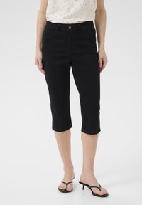 Jeans cropped neri in denim, con un classico design a cinque tasche, chiusura con bottone frontale e un leggero sbiadimento intorno alle ginocchia.