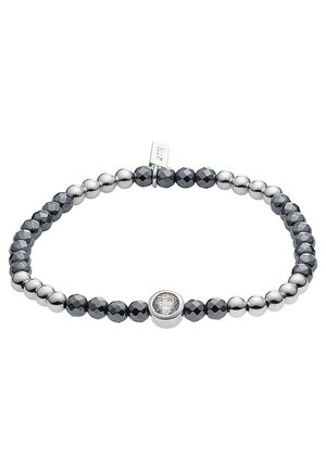 Bracelet extensible avec des perles argentées et facettées gris foncé alternées et une pierre précieuse ronde et claire centrale sertie en argent.