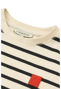 Cream cotton t-shirt with black stripes, featuring a red textured patch. Round neckline with visible stitching details.