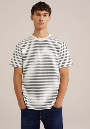 T-shirt blanc à manches courtes avec des rayures horizontales bleu marine, col rond et coupe décontractée. Associé à un jean bleu foncé.