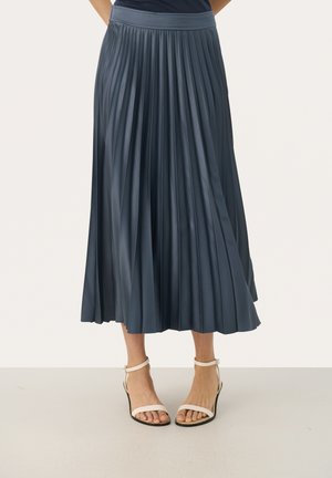 Pleated midi skirt in dark blue satin fabric, featuring a wide waistband and flowy design. Worn with white strappy heels.