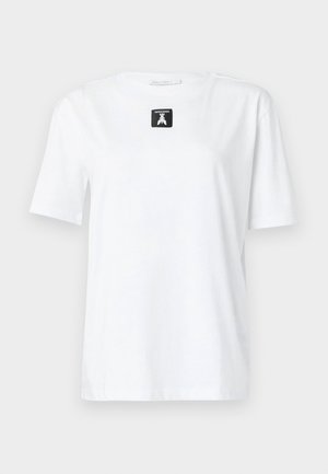 Tricou alb din bumbac, cu mâneci scurte, guler rotund și o etichetă rectangulară neagră pe față, care prezintă un logo. Design simplu și versatil.