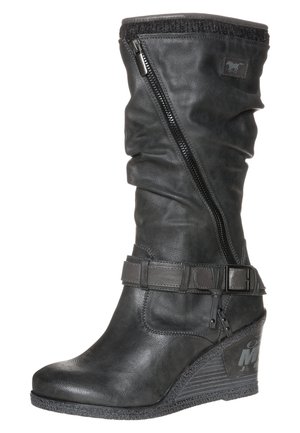 Czarna skórzana botka na koturnie do połowy łydki z bocznym zamkiem, ozdobnym paskiem z klamrą oraz teksturowaną gumową podeszwą.