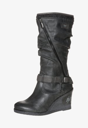 Botte compensée en cuir noir mi-mollet avec fermeture éclair latérale, sangle décorative et boucle, ainsi que semelle en caoutchouc texturée.