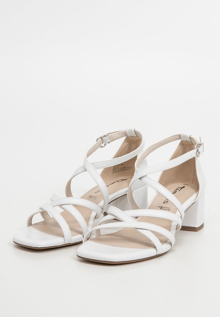Sandales à talons blancs avec un bout carré, comportant plusieurs lanières croisées et un talon bloc. Fini en cuir lisse et bride de cheville ajustable.