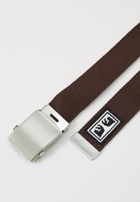 Brown woven fabric belt with a silver metal clasp and tip, featuring a black and white stitched logo near the tip, on a white background.