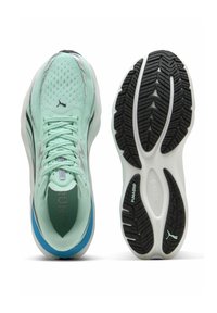 Baskets de sport vert clair avec une tige en maille respirante, des détails noirs et une semelle en caoutchouc noir texturé. Présente le logo Puma.