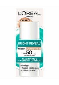L'Oréal Paris Bright Reveal UV Fluid in una bottiglia cilindrica bianca con dettagli in verde e bronzo. Contiene SPF 50, niacinamide e pigmenti luminosi.