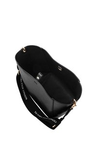 Schwarze Leder-Tote-Tasche mit goldfarbenen Beschlägen, offenem Design und einem schwarzen Tragegurt mit weißem Text. Das Innere ist ungefüttert und geräumig.