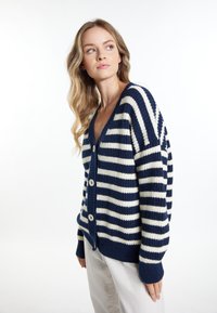 Cardigan a righe blu navy e crema con scollatura a V, chiusura con bottoni, texture a costine e maniche lunghe. Materiale in maglia morbida con vestibilità comoda.