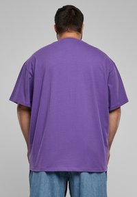 Tricou oversized violet, confecționat din bumbac, cu mâneci scurte, având un fit lejer și un design simplu. Textură moale, cu decolteu tip crew.