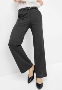 Brede broekspijpen in donkergrijze stof, met een aansluitende taille, riemlussen met een zilveren gesp, en een gladde textuur. Gecombineerd met zwarte schoenen.