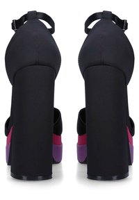 High-heeled shoes in black fabric with a square toe, featuring a thick black heel and color blocks in pink and purple along the sole.