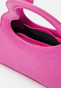 Kleine roze handtas met krokodillenstructuur, uitgerust met een ritssluiting binnenvak, een gladde afwerking en dubbele handvatten.