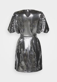 Skinande metallisk klänning gjord av reflekterande material, med kort längd, puffärmar och en design med nyckelhål i ryggen.