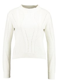 White knit sweater with a high neck, featuring textured cable patterns and openwork details. Ribbed cuffs and hem. Cropped design.