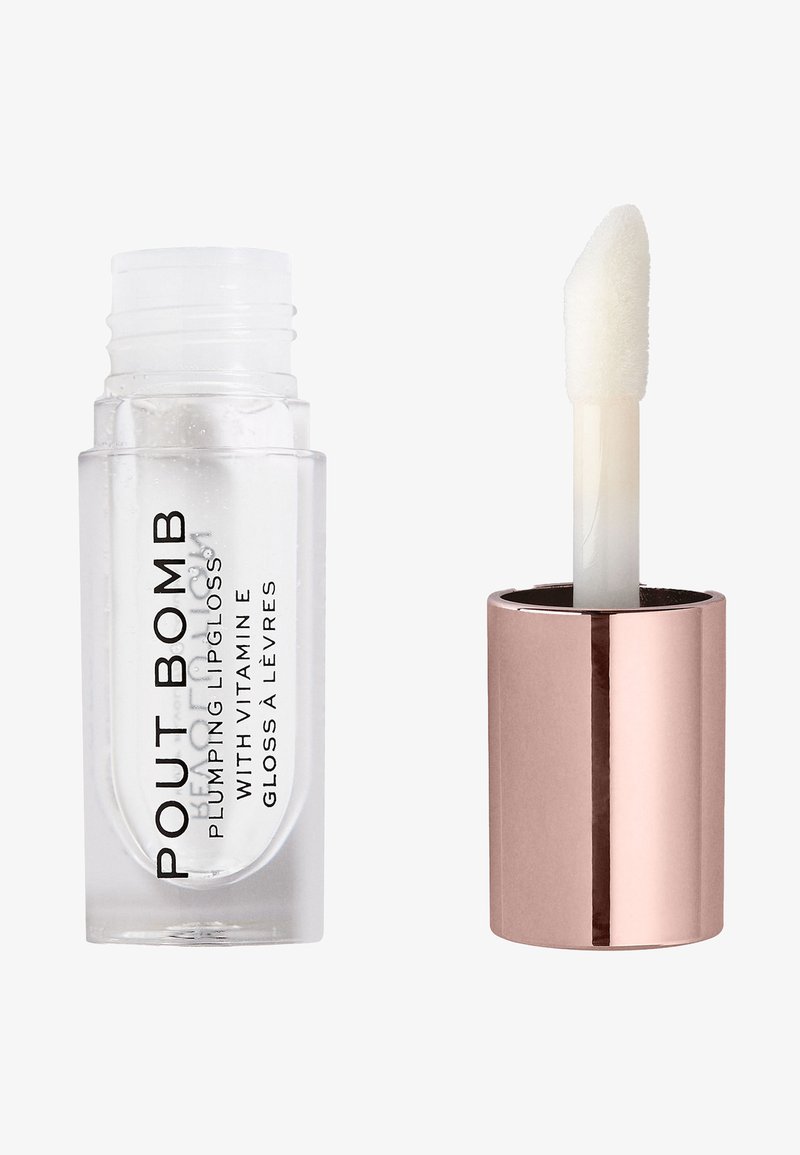 Tubo de plástico transparente que contiene brillo labial etiquetado como "POUT BOMB," con un aplicador blanco adjunto a una tapa metálica de oro rosa.