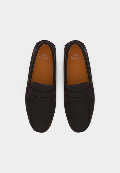 Paire de mocassins en cuir noir avec sangle à rabat, semelles intérieures couleur noisette et détails de couture discrets en rouge et bleu, vue de dessus sur fond blanc.