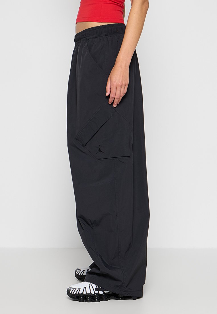 Pantaloni neri, alla moda e leggeri, con tasca cargo e logo Jordan sulla parte laterale. Accentuati da una cintura elastica.