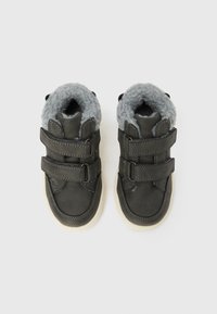 Σκούρα γκρι μποτάκια από συνθετικό δέρμα με απαλό γκρι επένδυση από φλις, διακοσμημένα με δύο ιμάντες βέλκρο και λευκή λαστιχένια σόλα. Στρογγυλεμένη μύτη.