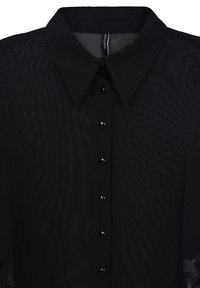 Schwarze Bluse mit transparenter Textur, klassischem Kragen und Knöpfen auf der Vorderseite. Glattes Material und glänzende schwarze Knopfakzente.