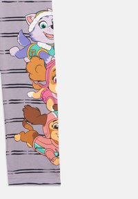 Legginsy w jasny fioletowym kolorze z postaciami psów z kreskówek w kolorowych strojach. Posiadają poziome czarne paski. Wykonane z miękkiego materiału, z elastycznym paskiem w talii.