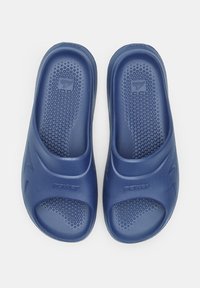 Sandali infradito in gomma blu con soletta testurizzata, design open-toe e logo del marchio. Parte superiore liscia con accenti curvi sottili.