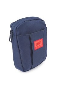 Bolsa de tela azul marino con una superficie texturizada, que presenta un bolsillo frontal y un prominente parche con el logo rojo de Skechers. Cierre con cremallera en la parte superior.